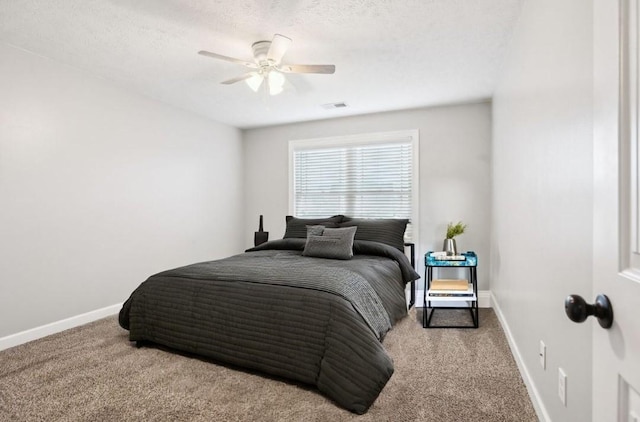 carpeted bedroom with a textured ceiling and ceiling fan