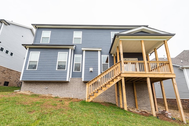 rear view of property with a lawn and a wooden deck