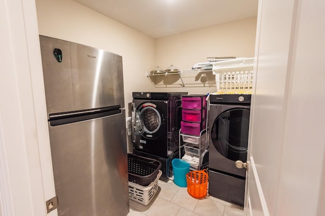 laundry area featuring light tile patterned flooring and washing machine and dryer