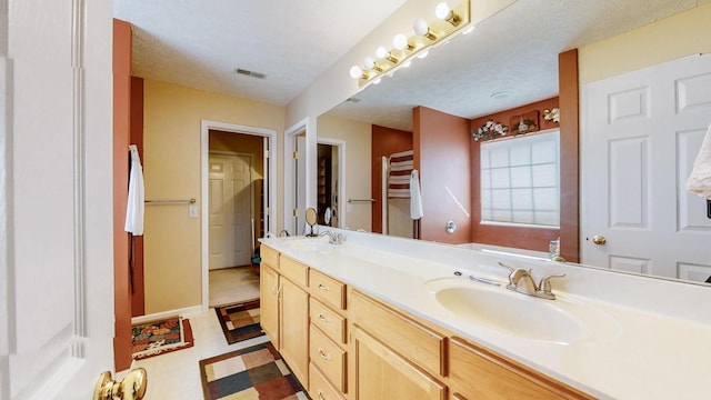 bathroom with vanity and a textured ceiling