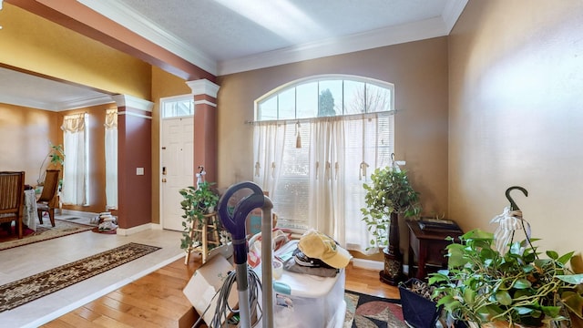 workout room featuring hardwood / wood-style flooring, ornamental molding, and ornate columns