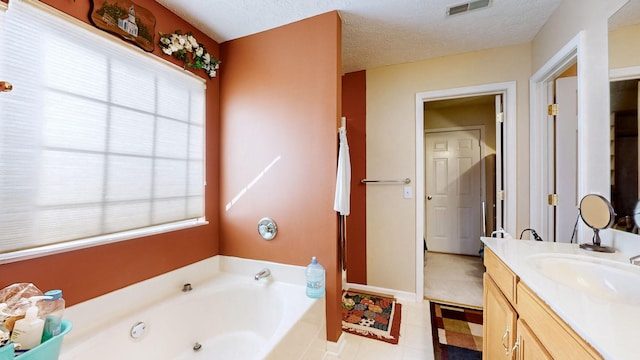 bathroom featuring a bathing tub, vanity, and a textured ceiling