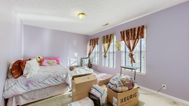 carpeted bedroom featuring a textured ceiling