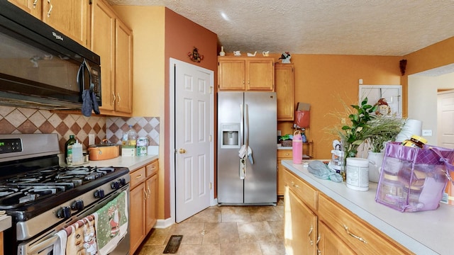 kitchen featuring appliances with stainless steel finishes, a textured ceiling, and backsplash