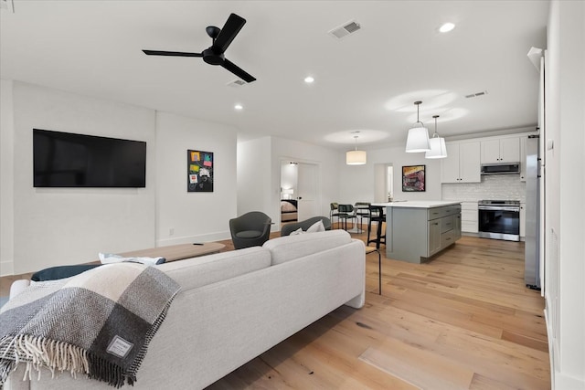 living room with ceiling fan and light hardwood / wood-style floors