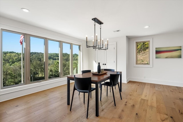 dining area with a notable chandelier and light wood-type flooring