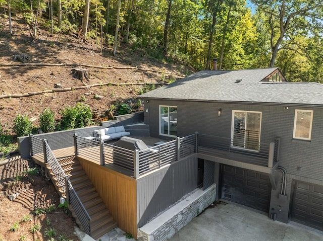 rear view of house featuring a garage and a deck