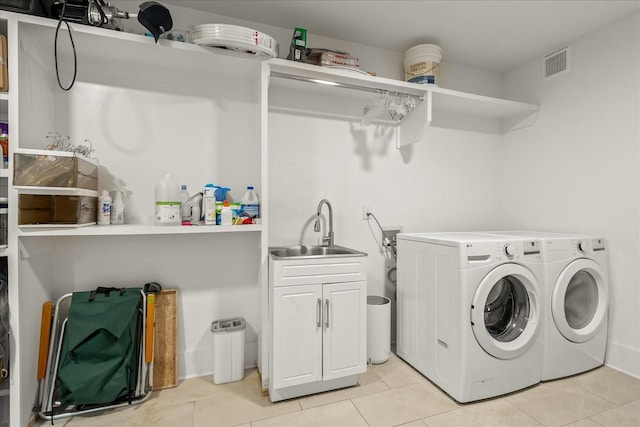 washroom featuring washer and dryer, light tile patterned floors, cabinets, and sink