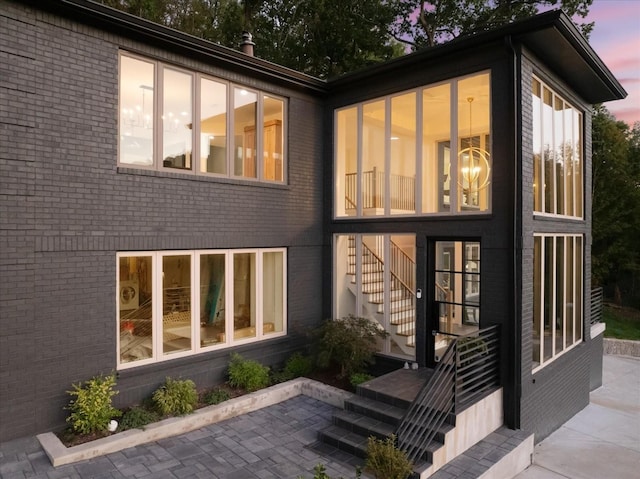 back house at dusk with a patio area