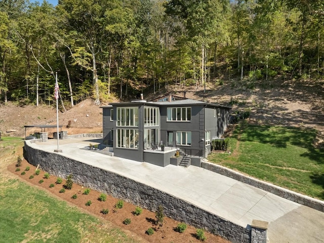 back of property with a yard and a patio