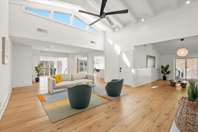 living room featuring beam ceiling, ceiling fan, high vaulted ceiling, and light wood-type flooring