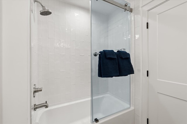 bathroom with bath / shower combo with glass door