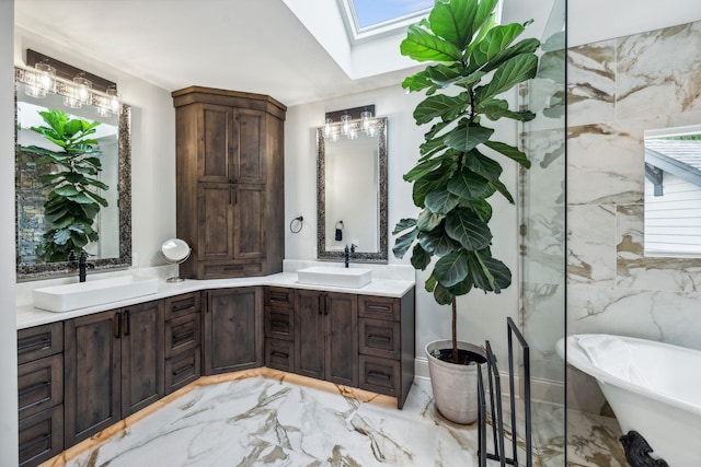 bathroom with a bath, vanity, and a skylight