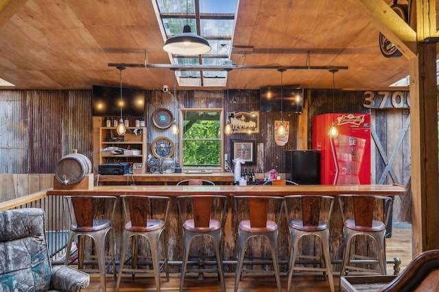 bar with black fridge, wood ceiling, and wooden walls