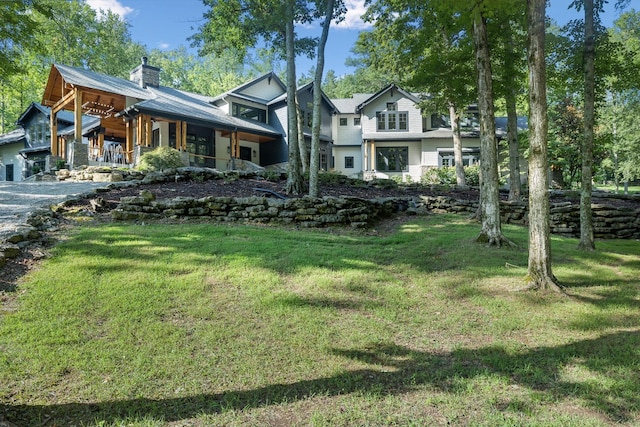 back of house with a lawn and covered porch