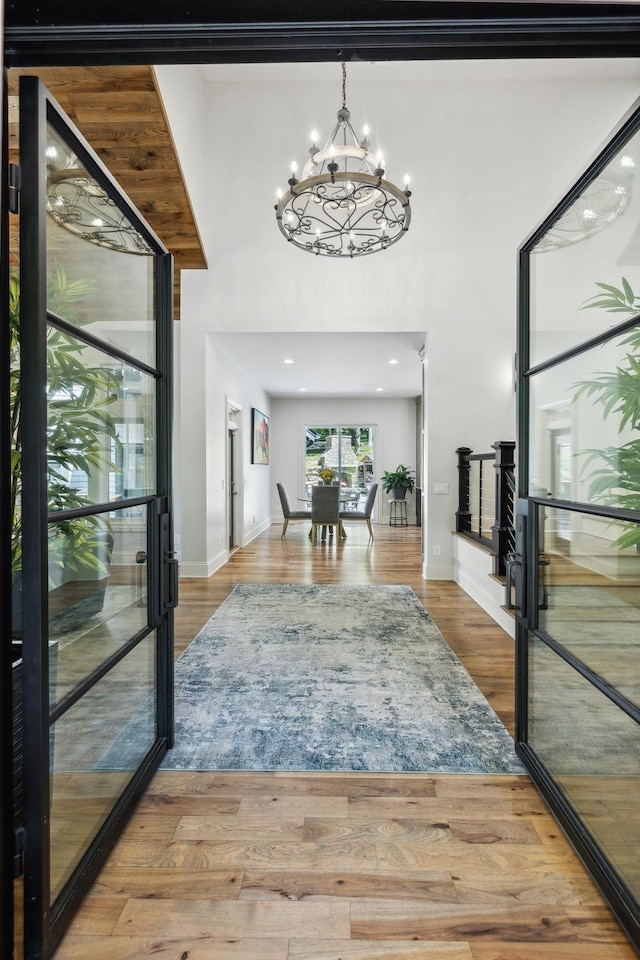 foyer with wood-type flooring and a chandelier