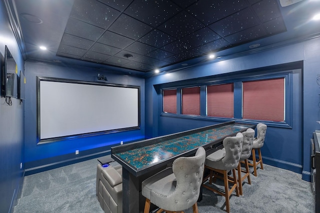 home theater room with carpet floors, a drop ceiling, and crown molding