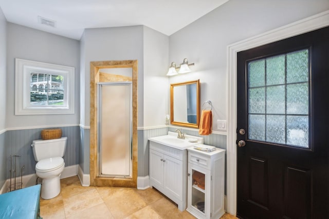 bathroom featuring tile patterned floors, vanity, toilet, and a shower with door