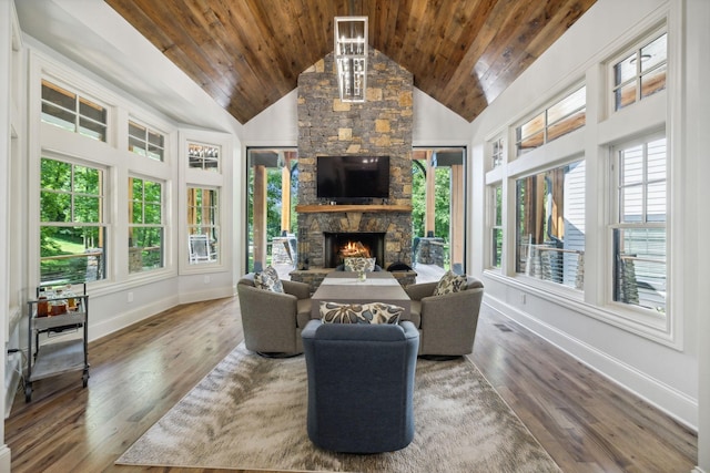 living room with hardwood / wood-style flooring, a stone fireplace, and wooden ceiling