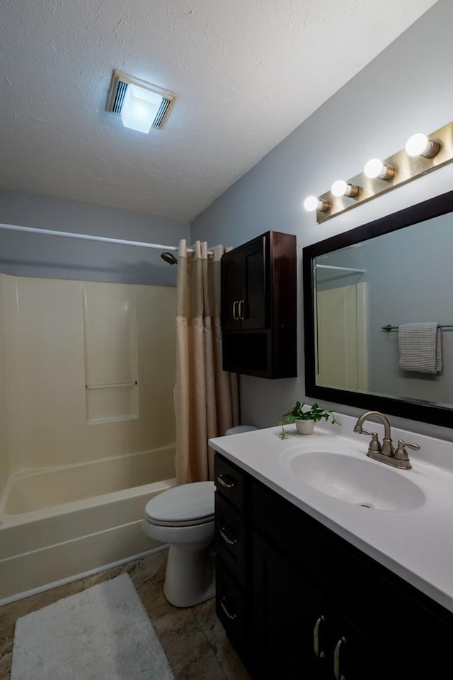 full bathroom featuring shower / bath combo, toilet, a textured ceiling, and vanity