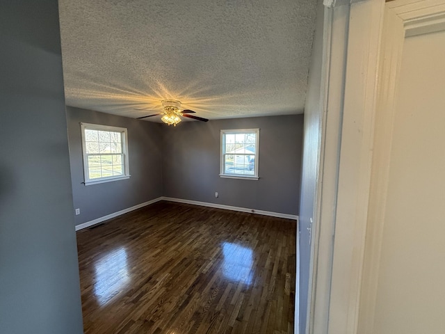 unfurnished room with a textured ceiling, dark hardwood / wood-style flooring, and ceiling fan