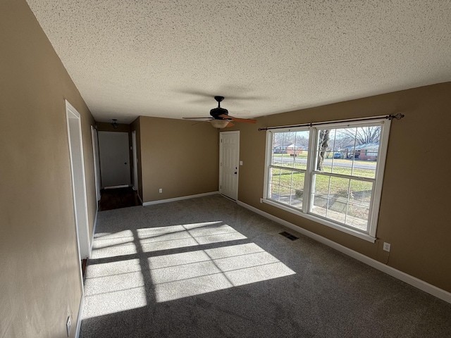 carpeted empty room with a textured ceiling and ceiling fan