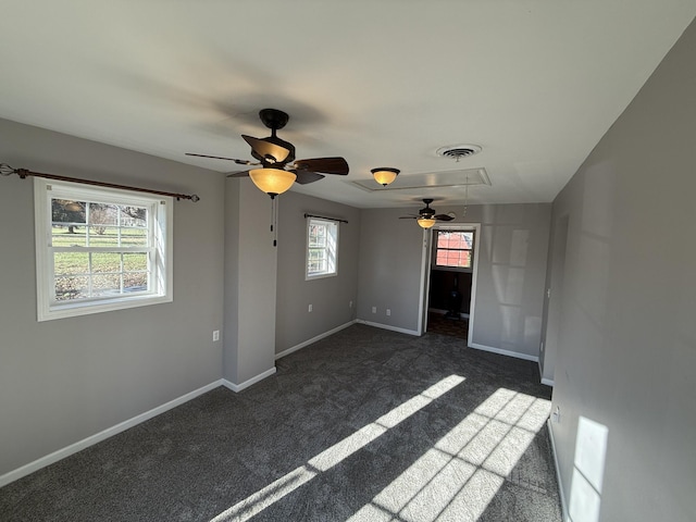 empty room with dark carpet and ceiling fan