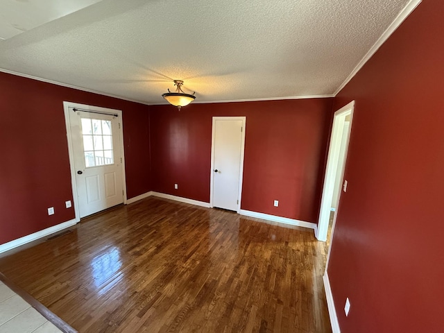 spare room featuring wood-type flooring, a textured ceiling, and ornamental molding