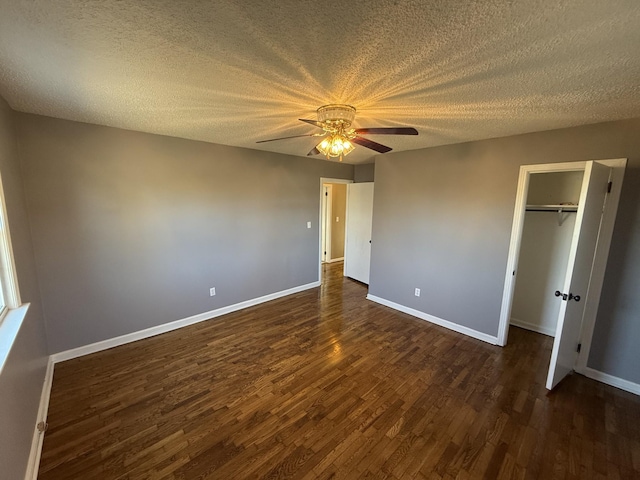 unfurnished bedroom featuring ceiling fan, a closet, dark wood-type flooring, and a textured ceiling