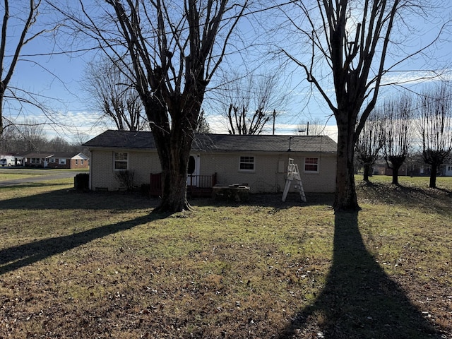 rear view of house featuring a lawn