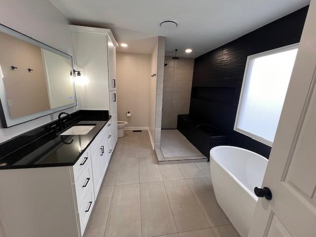 full bathroom with tile patterned flooring, vanity, toilet, and shower with separate bathtub