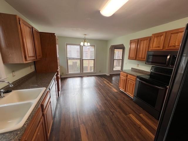 kitchen with sink, hanging light fixtures, dark hardwood / wood-style flooring, black electric range oven, and a chandelier