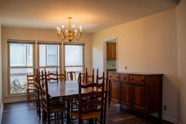 dining space featuring dark hardwood / wood-style flooring, a healthy amount of sunlight, and an inviting chandelier