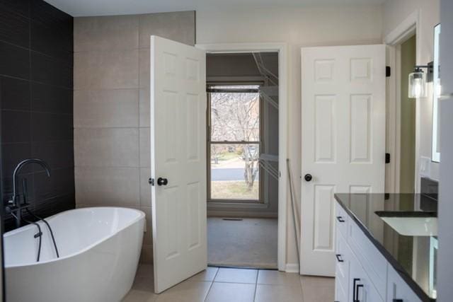 bathroom with tile patterned floors and a tub