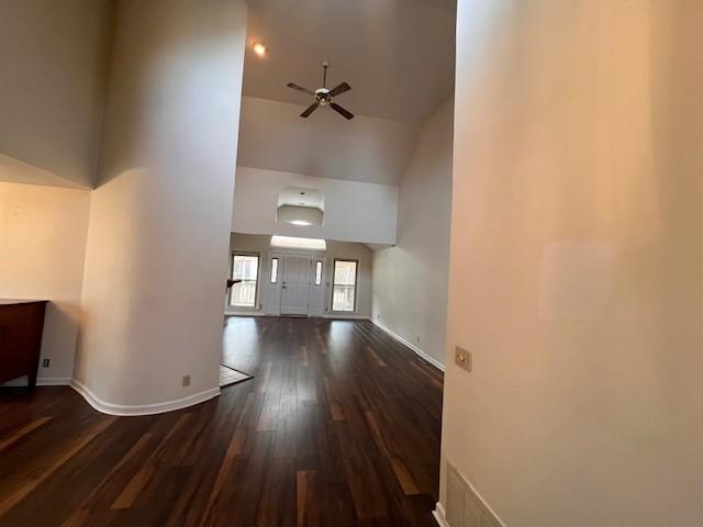 unfurnished living room featuring ceiling fan, dark hardwood / wood-style flooring, and high vaulted ceiling