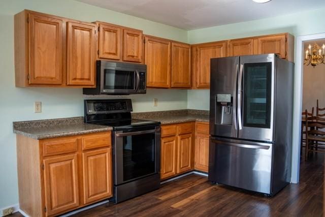 kitchen with stainless steel refrigerator with ice dispenser, dark hardwood / wood-style flooring, an inviting chandelier, and black electric range oven