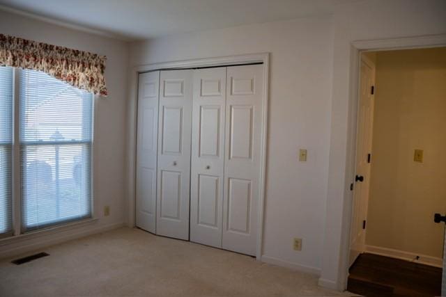 unfurnished bedroom featuring carpet and a closet