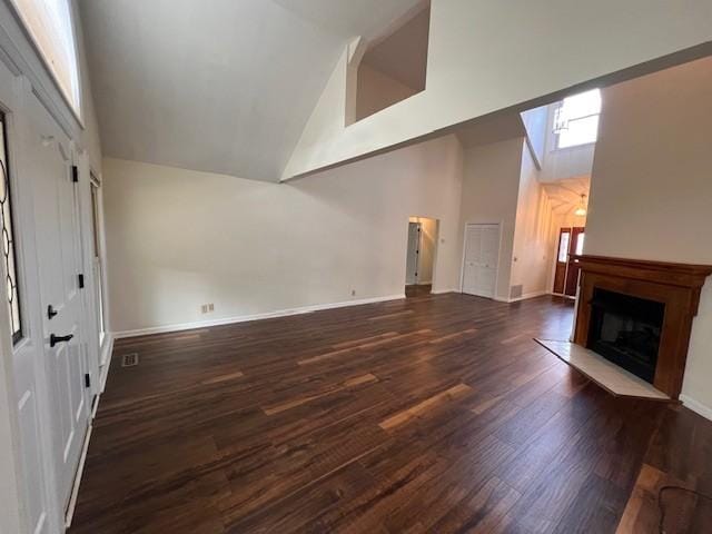 unfurnished living room featuring dark hardwood / wood-style floors and high vaulted ceiling