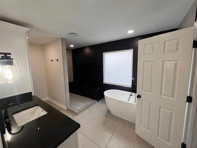 bathroom with tile patterned flooring, shower with separate bathtub, and vanity