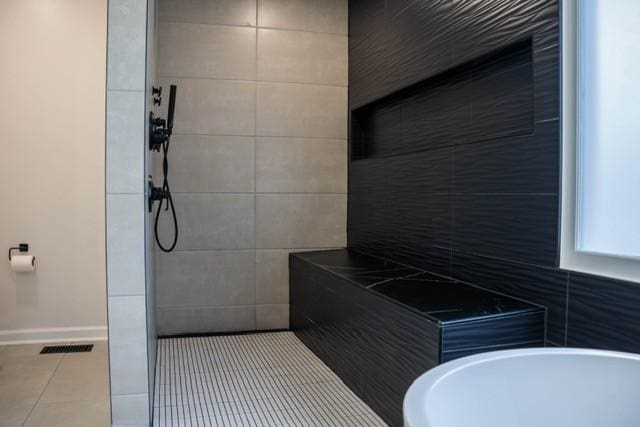 bathroom with plus walk in shower, tile patterned flooring, and tile walls