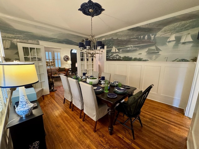 dining area featuring a chandelier, wood-type flooring, and ornamental molding