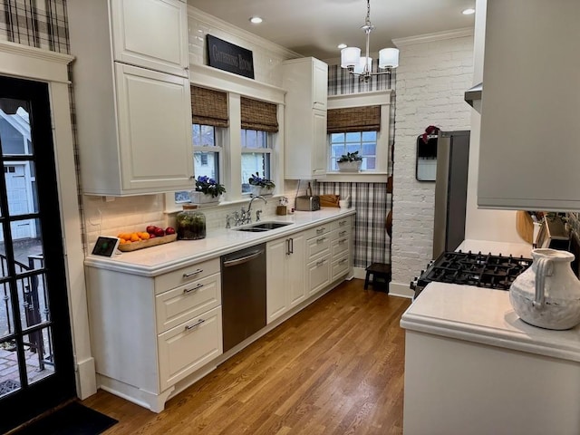 kitchen with stainless steel dishwasher, sink, pendant lighting, light hardwood / wood-style flooring, and white cabinetry