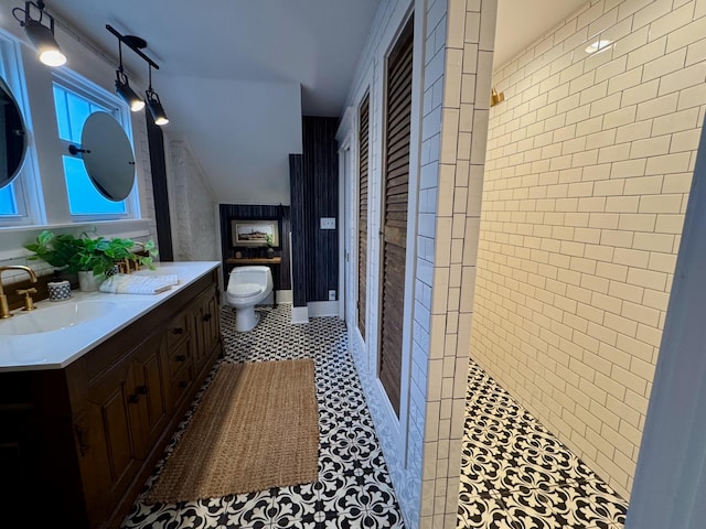 bathroom with tile patterned flooring, vanity, toilet, and a shower