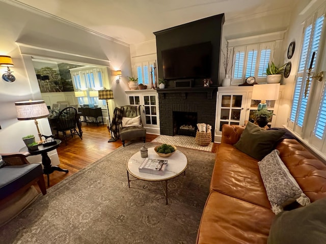 living room with hardwood / wood-style flooring and a brick fireplace