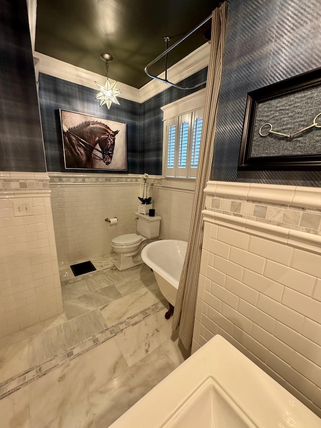 bathroom with a tub to relax in, toilet, and tile walls