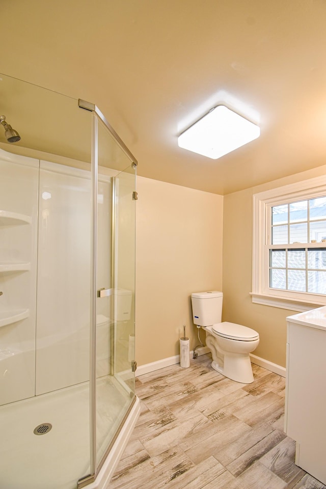 bathroom with vanity, toilet, and a shower with door