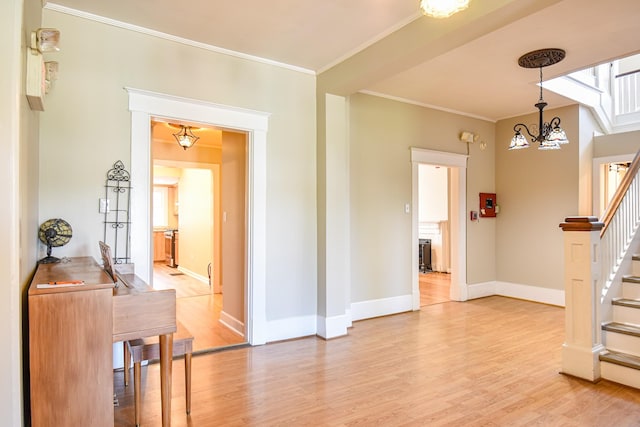 foyer entrance featuring light hardwood / wood-style flooring, a chandelier, and ornamental molding