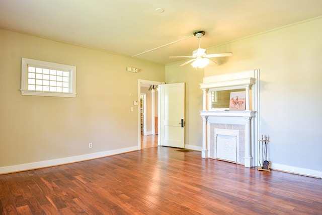 unfurnished living room featuring ceiling fan, a fireplace, and dark wood-type flooring