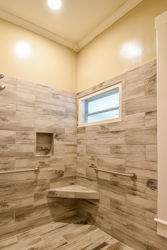 bathroom with tiled shower and crown molding