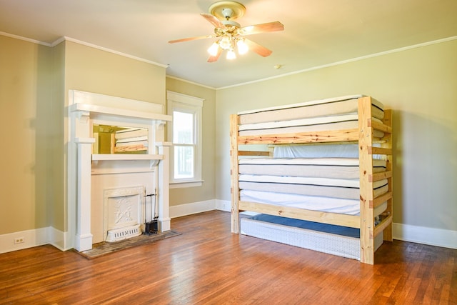 unfurnished bedroom featuring wood-type flooring, ceiling fan, and crown molding